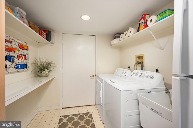 clothes washing area with washing machine and dryer and sink