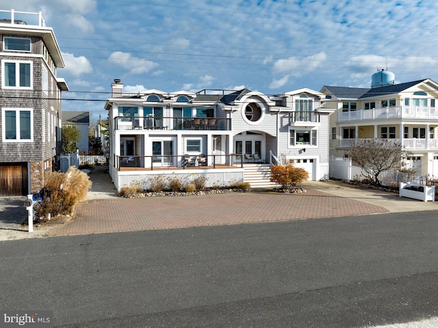 view of front of property featuring a balcony and a garage