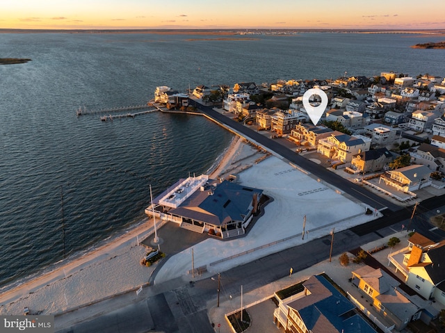 aerial view at dusk featuring a water view