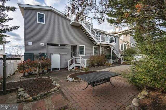 rear view of property featuring a balcony and a patio