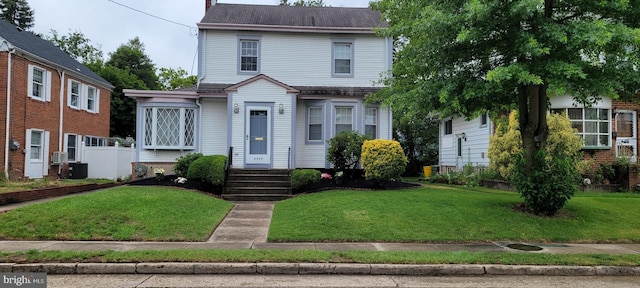 view of front facade featuring central AC and a front yard