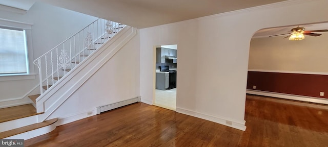 stairway with a baseboard radiator, hardwood / wood-style flooring, crown molding, and ceiling fan