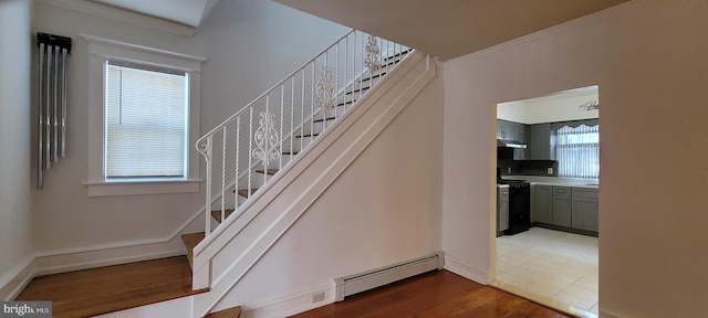 stairway with hardwood / wood-style floors, a baseboard radiator, and crown molding