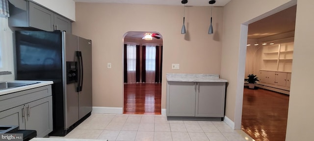 kitchen featuring ceiling fan, a baseboard heating unit, pendant lighting, stainless steel fridge with ice dispenser, and gray cabinets