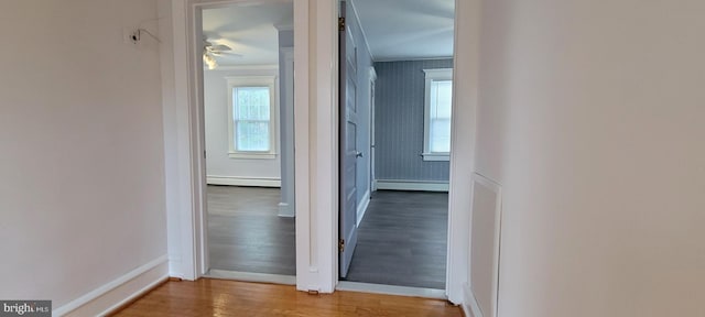 corridor with hardwood / wood-style floors and a baseboard radiator