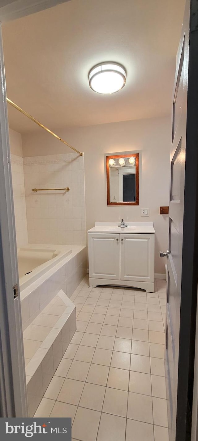 bathroom with tile patterned floors, vanity, and a tile shower