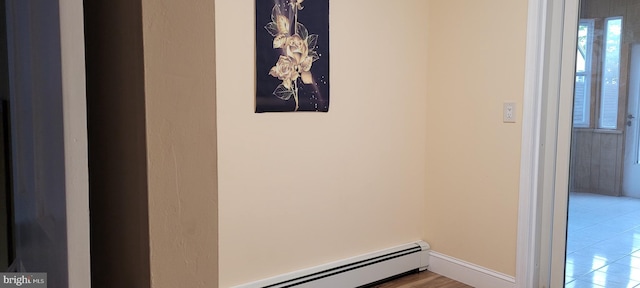 corridor featuring a baseboard radiator and light tile patterned flooring