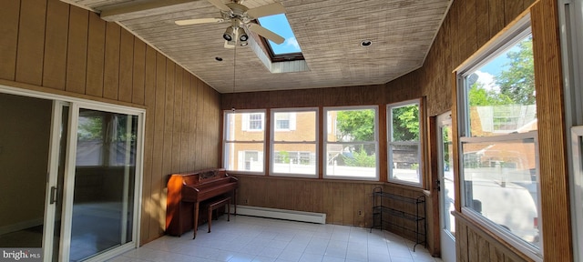 unfurnished sunroom featuring vaulted ceiling with skylight, ceiling fan, and baseboard heating