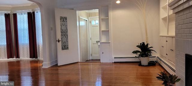 interior space with ornamental molding and hardwood / wood-style flooring