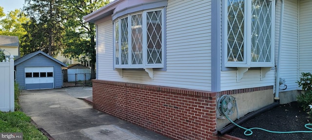 view of side of home featuring a garage and an outbuilding