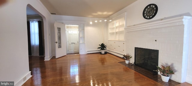 corridor with dark hardwood / wood-style flooring and a baseboard heating unit