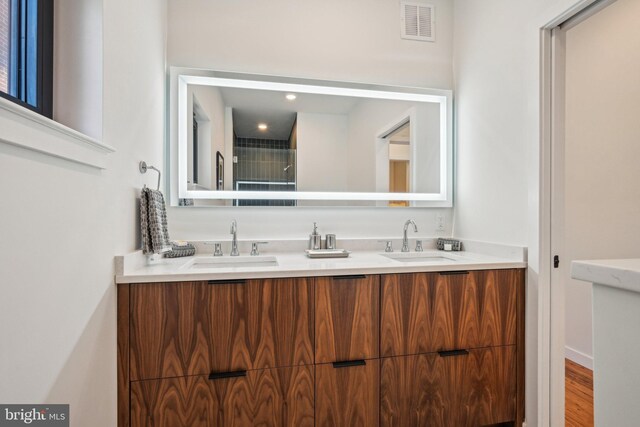 bathroom with double vanity and wood finished floors