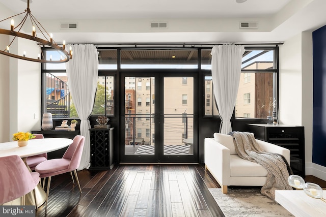 entryway featuring visible vents, dark wood finished floors, and a notable chandelier