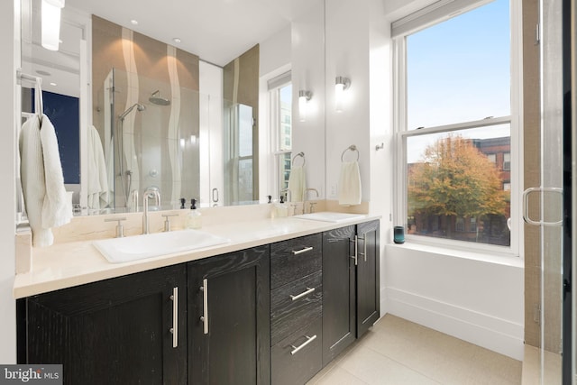 bathroom with double vanity, a stall shower, tile patterned flooring, and a sink