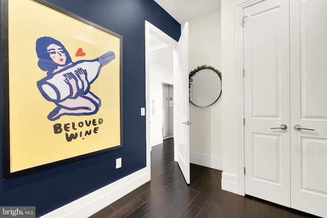 hallway with dark wood-type flooring and baseboards