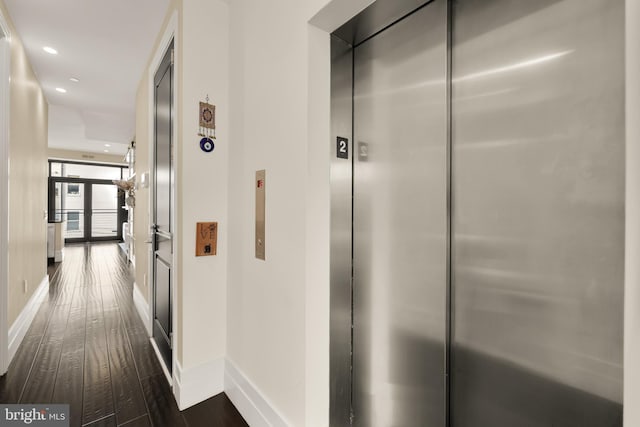 hallway with recessed lighting, elevator, baseboards, and dark wood-style flooring