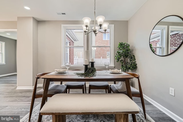 dining room with wood-type flooring, an inviting chandelier, and a healthy amount of sunlight