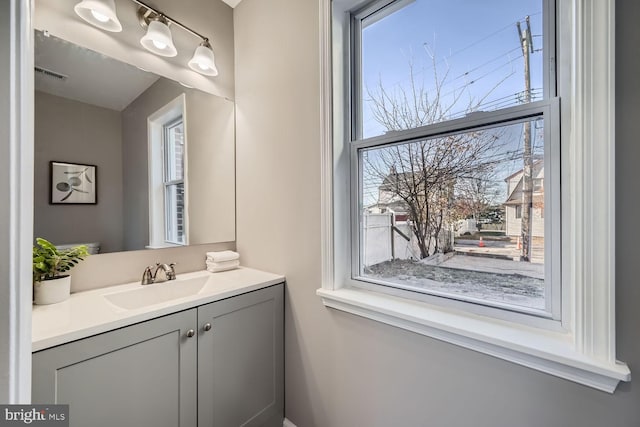 bathroom with a wealth of natural light, visible vents, and vanity