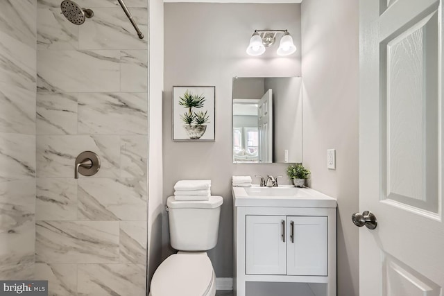 full bath with toilet, a tile shower, and vanity