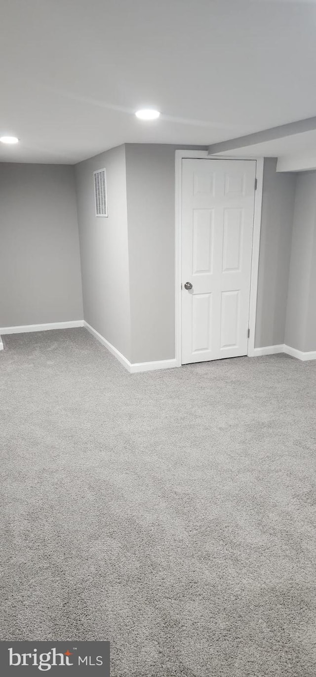 finished basement featuring visible vents, baseboards, and carpet flooring