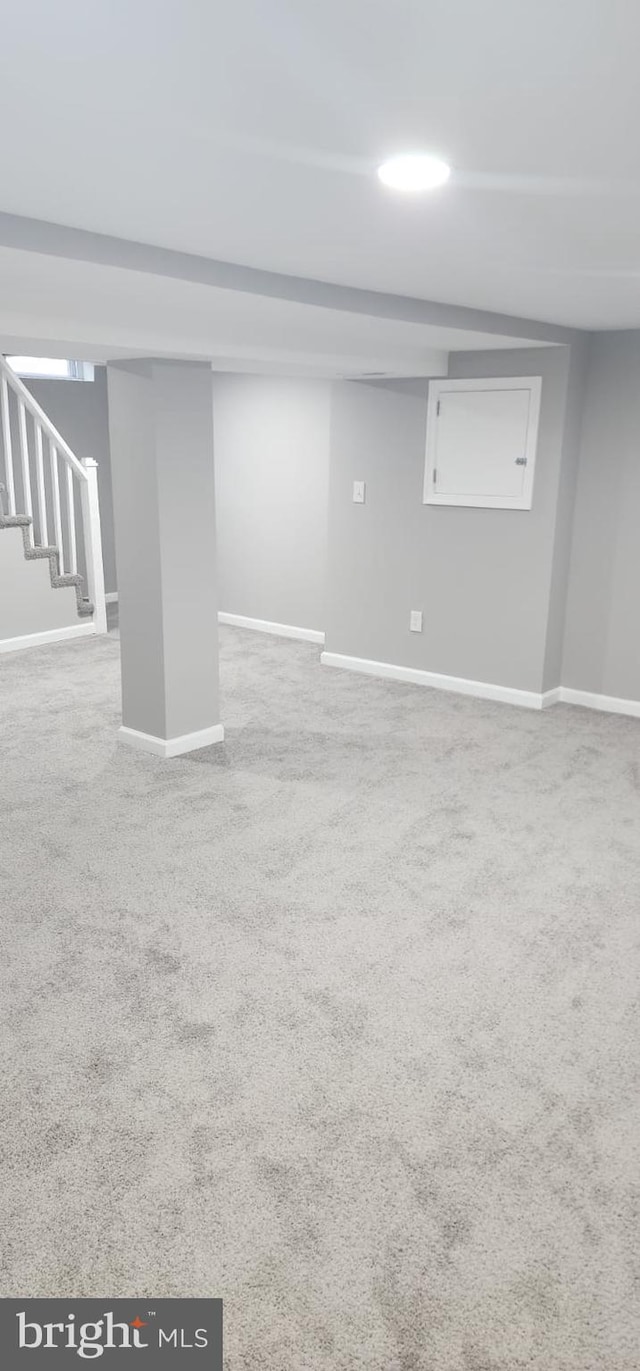 finished basement featuring carpet, stairway, and baseboards