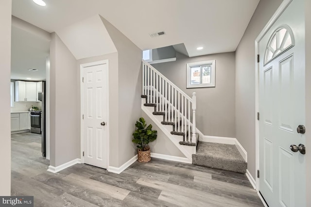 entryway featuring stairs, wood finished floors, visible vents, and baseboards