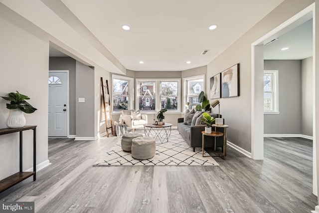 living area featuring recessed lighting, plenty of natural light, baseboards, and wood finished floors