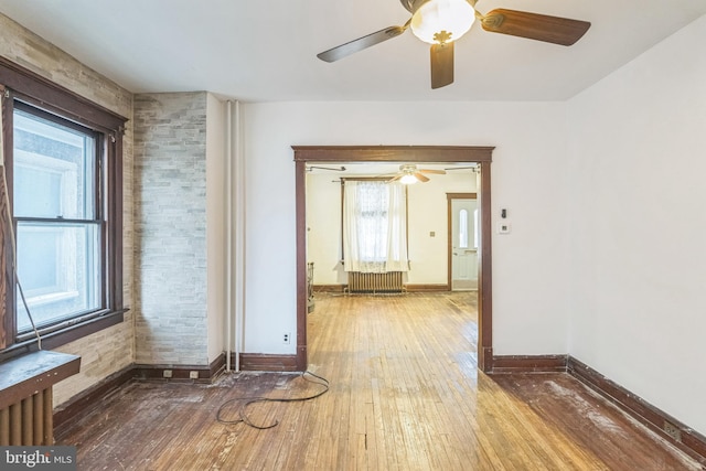 empty room with hardwood / wood-style floors and plenty of natural light