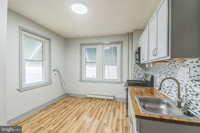 kitchen featuring stainless steel appliances, butcher block countertops, a wealth of natural light, and sink