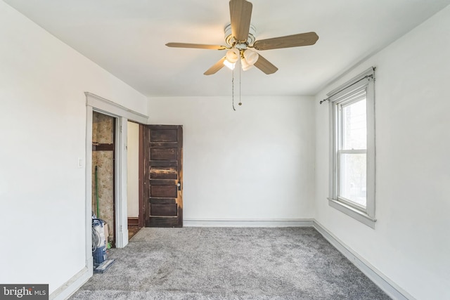 carpeted spare room featuring ceiling fan