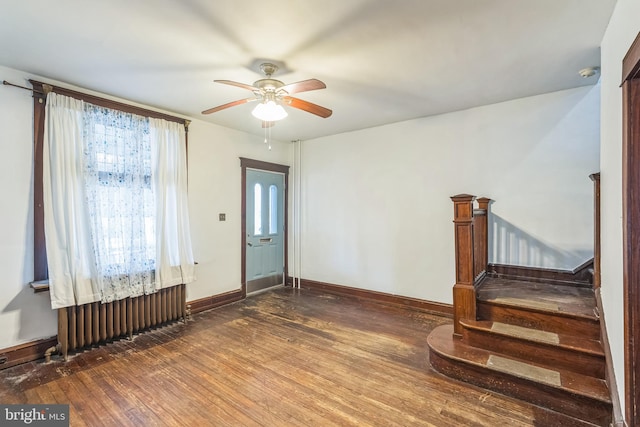 foyer entrance featuring dark hardwood / wood-style floors, ceiling fan, and radiator