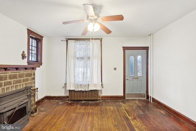 foyer entrance with a fireplace, radiator heating unit, dark hardwood / wood-style floors, and ceiling fan