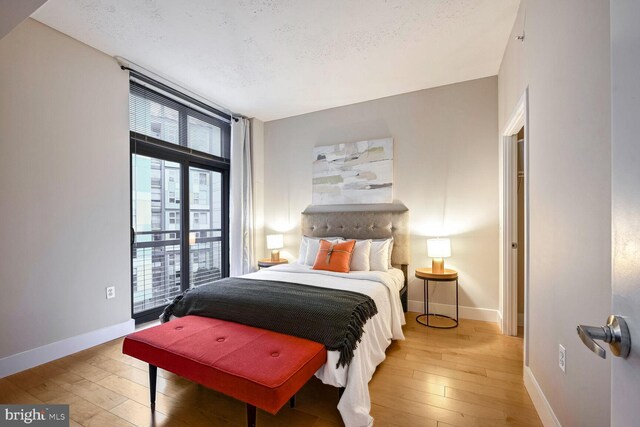 bedroom with a textured ceiling and hardwood / wood-style flooring