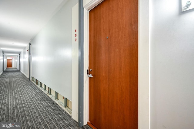 hall featuring dark colored carpet