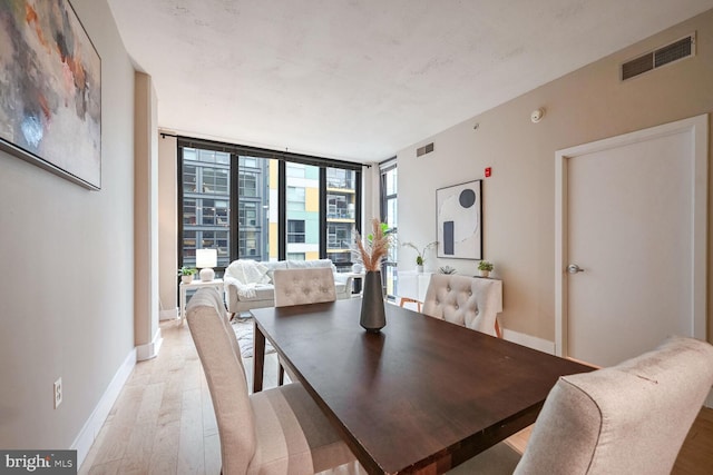 dining area featuring floor to ceiling windows and light wood-type flooring