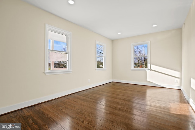 spare room with recessed lighting, wood finished floors, and baseboards