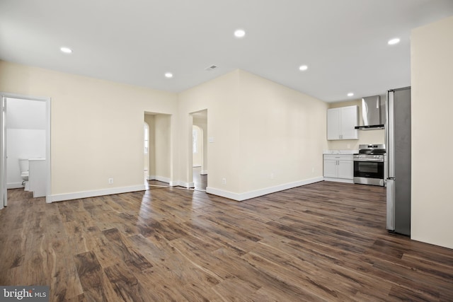 unfurnished living room with recessed lighting, dark wood-type flooring, and baseboards