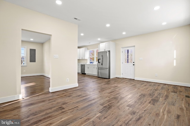 unfurnished living room with electric panel, visible vents, recessed lighting, and dark wood-style floors