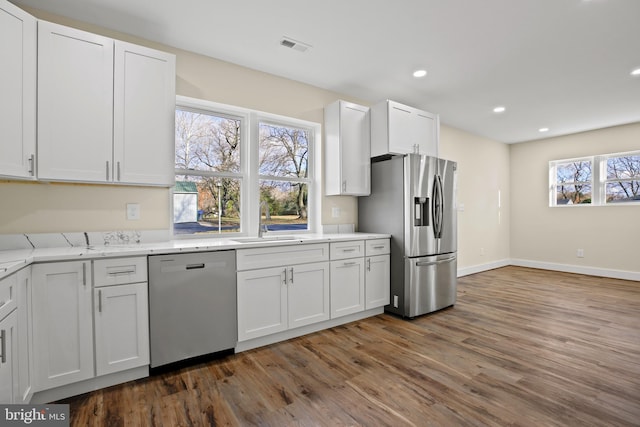 kitchen with dark wood finished floors, dishwashing machine, recessed lighting, and stainless steel fridge with ice dispenser