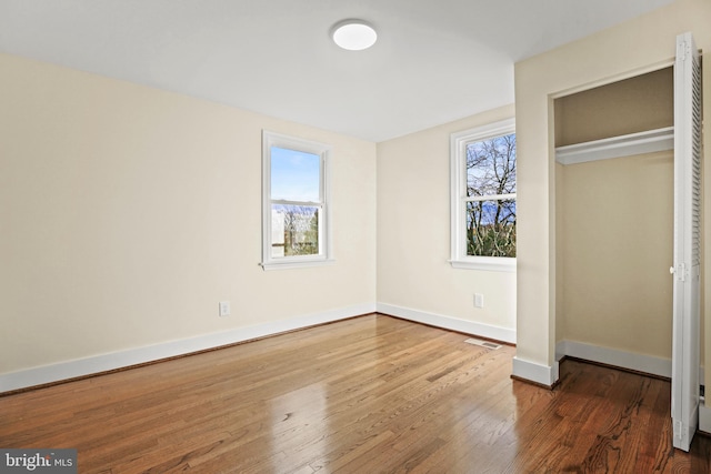 unfurnished bedroom with visible vents, baseboards, and wood-type flooring