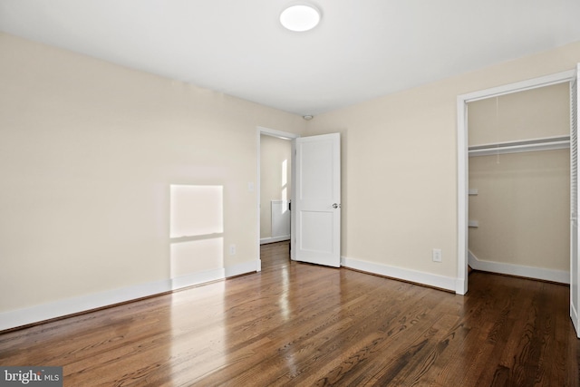 unfurnished bedroom with a closet, baseboards, and wood finished floors