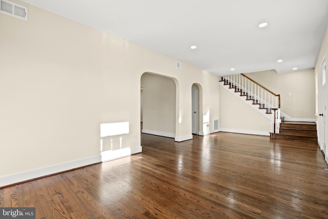 empty room with stairway, wood finished floors, visible vents, baseboards, and recessed lighting