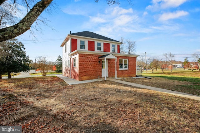 view of front of home featuring a front yard and brick siding