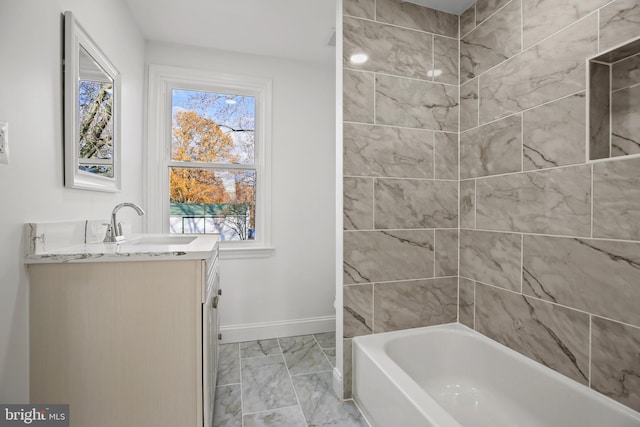 full bathroom with marble finish floor, vanity, and baseboards