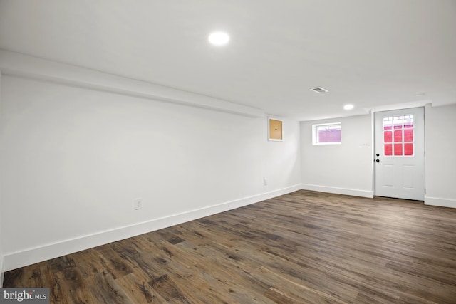 basement with dark wood finished floors, recessed lighting, visible vents, and baseboards