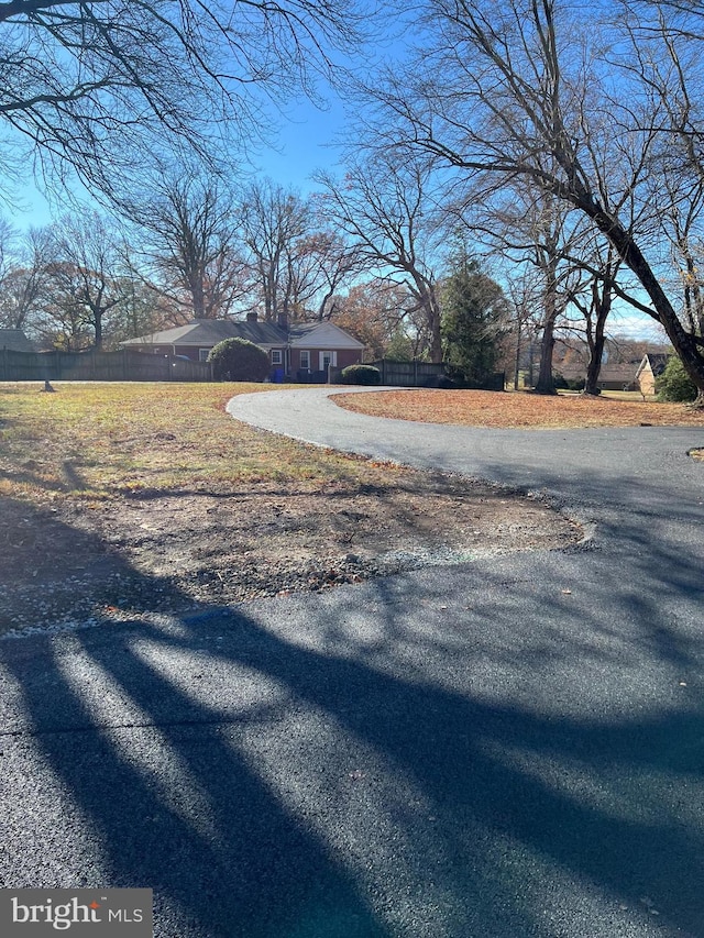 view of yard with driveway and fence