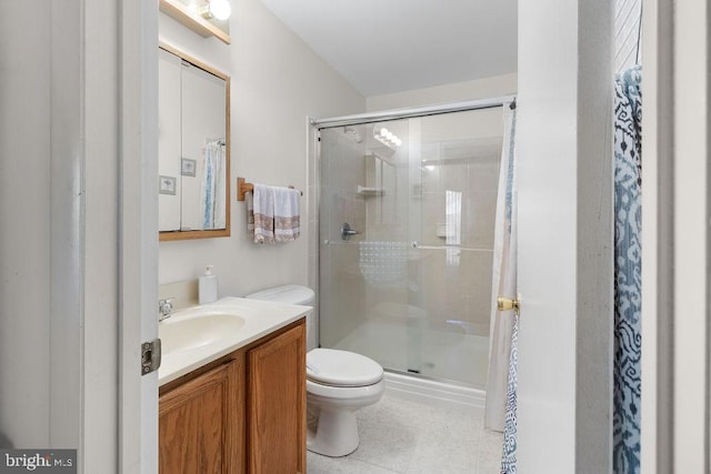 bathroom with tile patterned flooring, a shower with door, vanity, and toilet