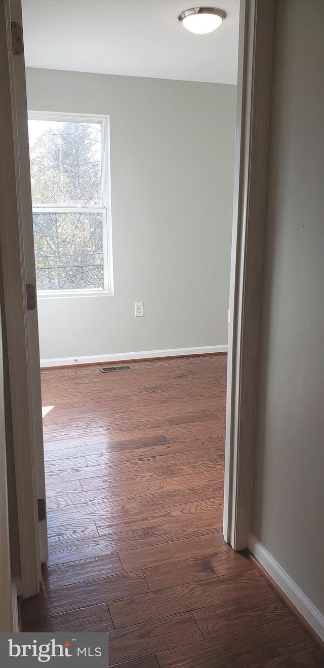 unfurnished room featuring dark wood-type flooring