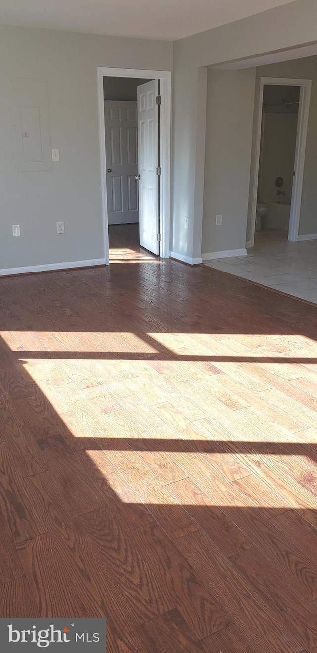 unfurnished room with wood-type flooring and electric panel