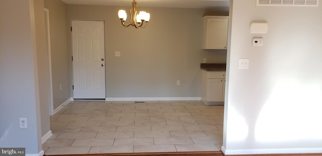 unfurnished dining area with light tile patterned flooring and a chandelier